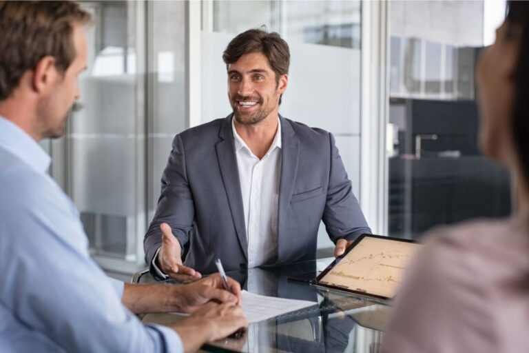 assessor de investimentos: um homem jovem prestando assessoria de investimento para um casal.