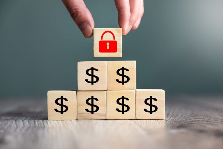 investimento seguro: caixinha de madeiras com o símbolo do $ formando uma piramide e no topo um cadeado vermelho fechado desenhado na última caixinha.
