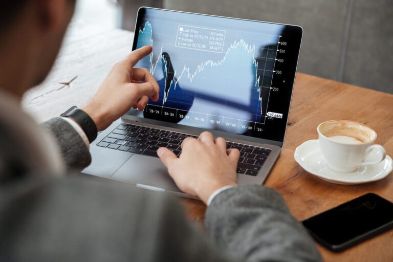 marcação a mercado: uma pessoa olhando as oscilações do mercado financeiro na tela de um notebook.
