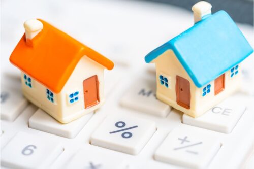 taxa de vacância: duas casinhas em miniatura em cima de um teclado de um computador.