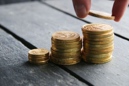 dpge: pilhas de moedas douradas crescentes.