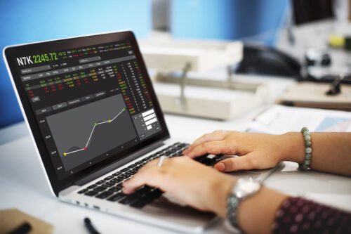 mercado fracionário de ações: uma pessoa acompanhando o mercado de ações por meio do notebook.
