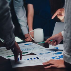 follow on: um grupo de pessoas reunidas analisando gráficos.