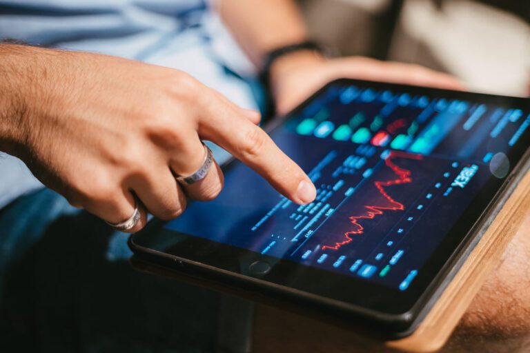 indicadores fundamentalistas: uma pessoa acompanhando as oscilações do mercado por meio do tablet.