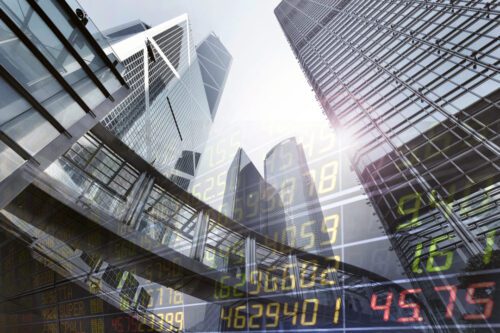 Mid Caps: prédios em segundo plano e valores de ações em primeiro plano.