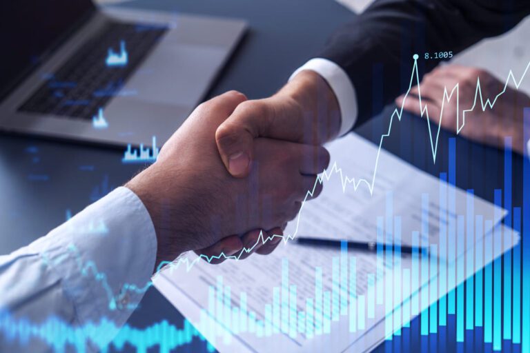 empresa de investimentos: no primeiro plano gráficos de barra e de linha na cor azul. E duas pessoas apertando as mãos.