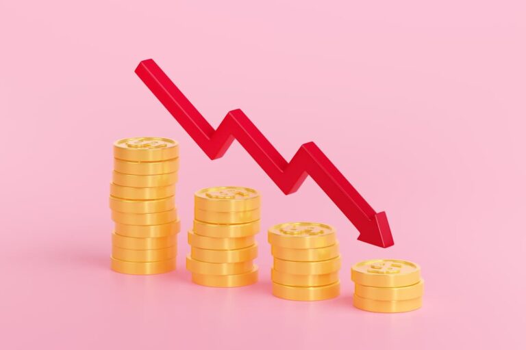 deflação: pilhas de moedas douradas e uma seta decrescendo.