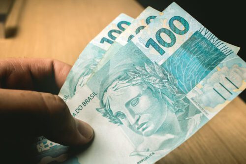 CDB ou Tesouro Direto: três notas de 100 reais.