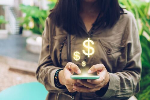 diferença entre ted e doc: uma mulher digitando no celular e alguns símbolos de $ em cima da tela.