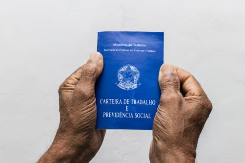 tipos de aposentadoria: uma pessoa segurando uma carteira de trabalho.