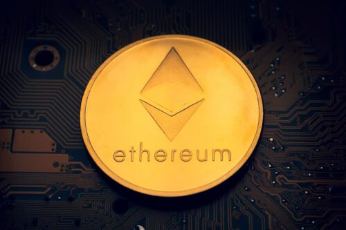 Imagem de uma moeda dourada representando a Ethereum sobre um circuito eletrônico, simbolizando tecnologia blockchain.