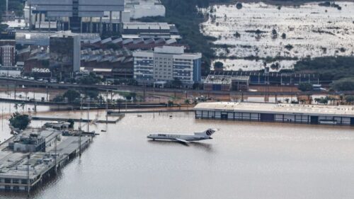 avião pousado em uma rua inundada
