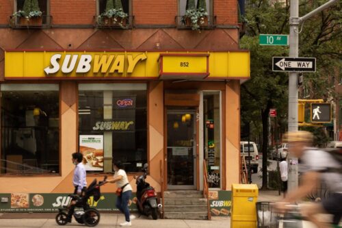 loja subway com pessoas passando na frente