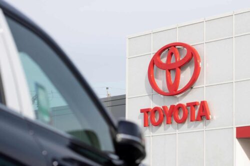 carro estacionado em frente a um prédio com logo da Toyota
