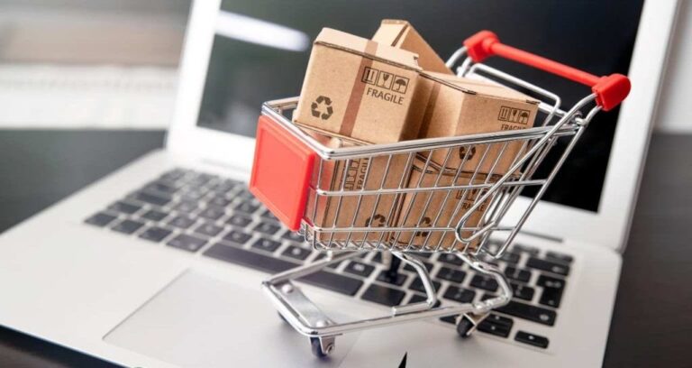 carrinho de compras em miniatura em cima de um computador representando a taxação de compras importados