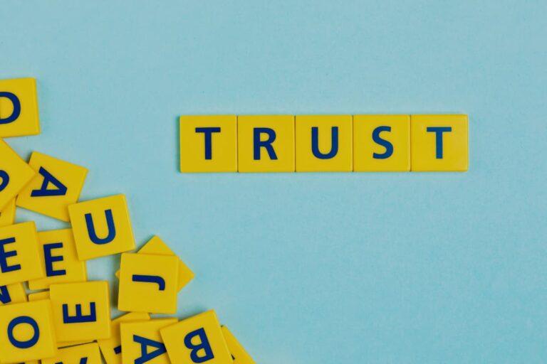 Imagem com a palavra Trust em peças de letras amarelas, simbolizando confiança e planejamento financeiro em investimentos.