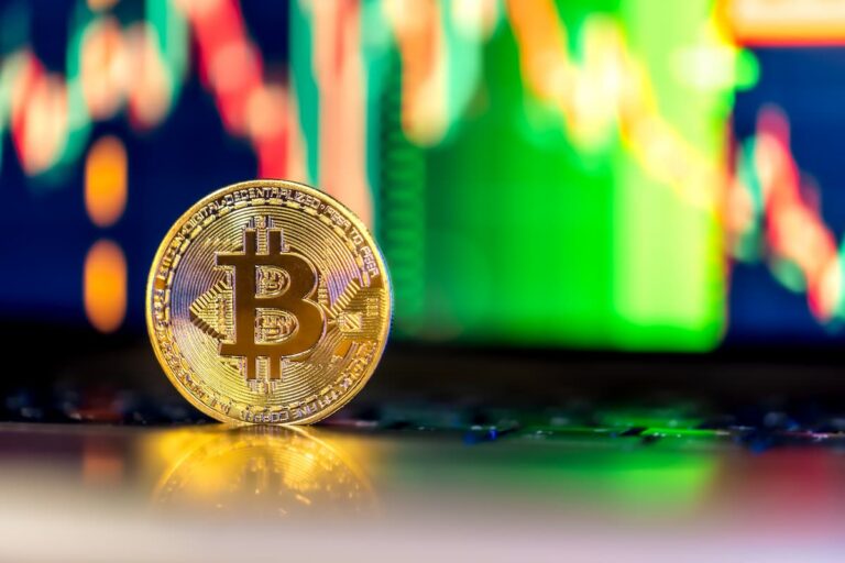 Imagem de uma moeda dourada de Bitcoin com gráficos coloridos ao fundo, representando o conceito de staking de criptomoedas.