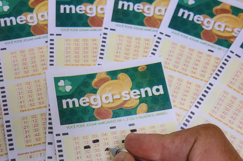 Imagem de várias apostas da Mega-Sena 2872 com boleto e uma mão segurando uma caneta, destacando o resultado do sorteio
