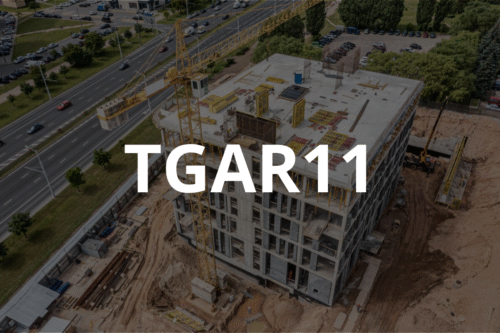 Construção de edifício em andamento com torre de grua e infraestrutura de obras na frente, relacionado ao setor imobiliário, foco na seguridade financeira com TGAR11.
