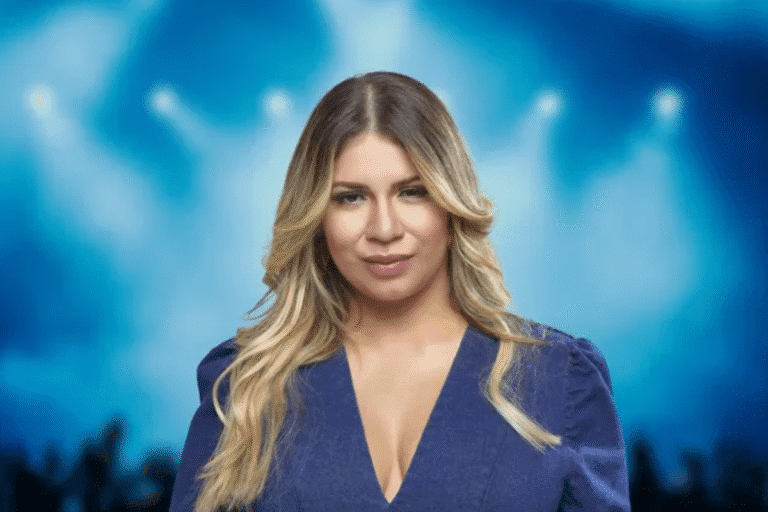 Imagem da cantora Marília Mendonça com um fundo de holofotes, similar a um show.