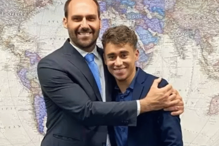 Foto dos deputados Eduardo Bolsonaro e Nikolas Ferreira, se abraçando.