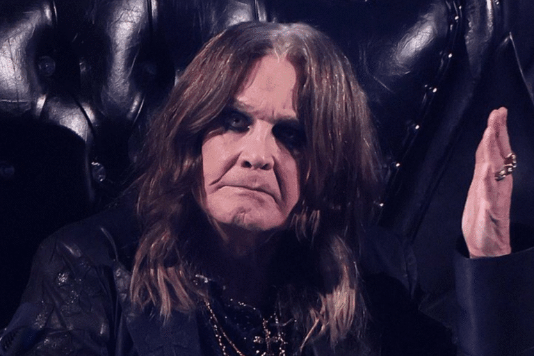 Foto do ícone do rock Ozzy Osbourne de mãos levantadas.
