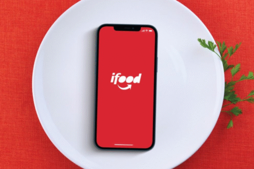 Foto de um prato sobreposto por um celular com a logotipo do IFood.