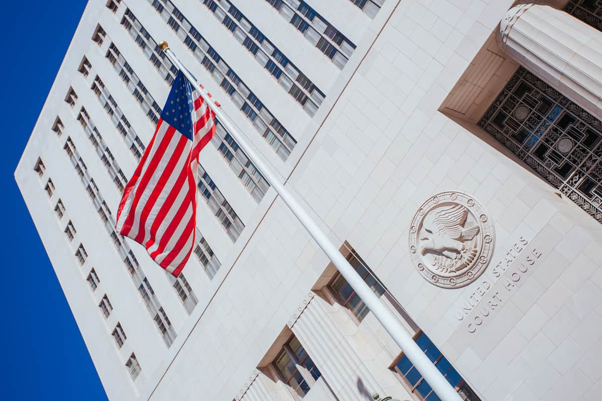 Fachada de um tribunal dos EUA com bandeira americana e selo oficial, ilustrando o tema o que é a SEC.