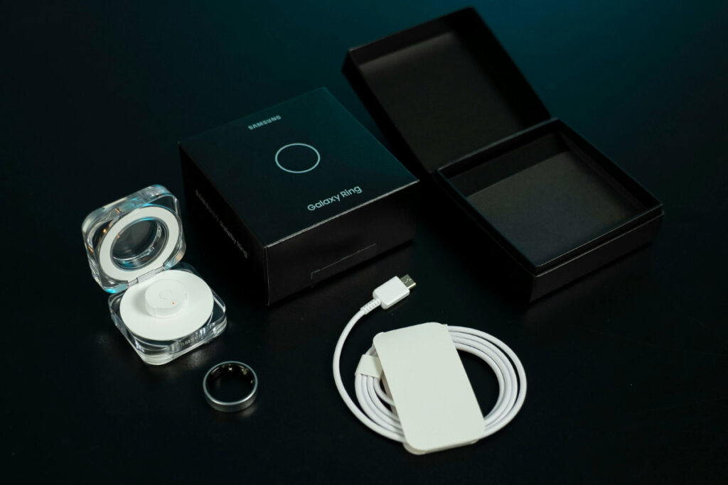 Caixa do Galaxy Ring com carregador, cabo e anel inteligente Samsung, destacando acessórios do dispositivo.