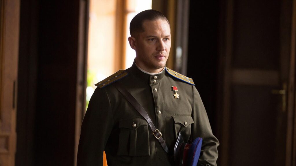 Tom Hardy em uniforme militar soviético no filme Crimes Ocultos, retratando clima de repressão e tensão política.