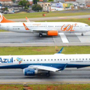 Aeronaves da Gol e da Azul no aeroporto durante o pouso, com destaque para o avião da Gol com cores laranja e logo visível na imagem.