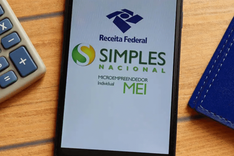 Documento digital mostrando o programa Simples Nacional para microempreendedor individual (MEI), incluindo o logo da Receita Federal, em destaque na tela de um celular. Ao lado, uma calculadora e uma carteira azul de couro no ambiente de trabalho.