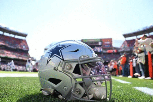 Capacete de futebol americano com logo da equipe Cowboys em campo de estádio, preparado para a partida