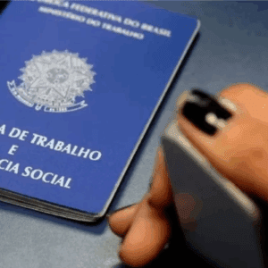 Pessoa colocando a biometria próximo à carteira de trabalho e previdência social no buffet de fotos, com foco na carteira azul do documento oficial.