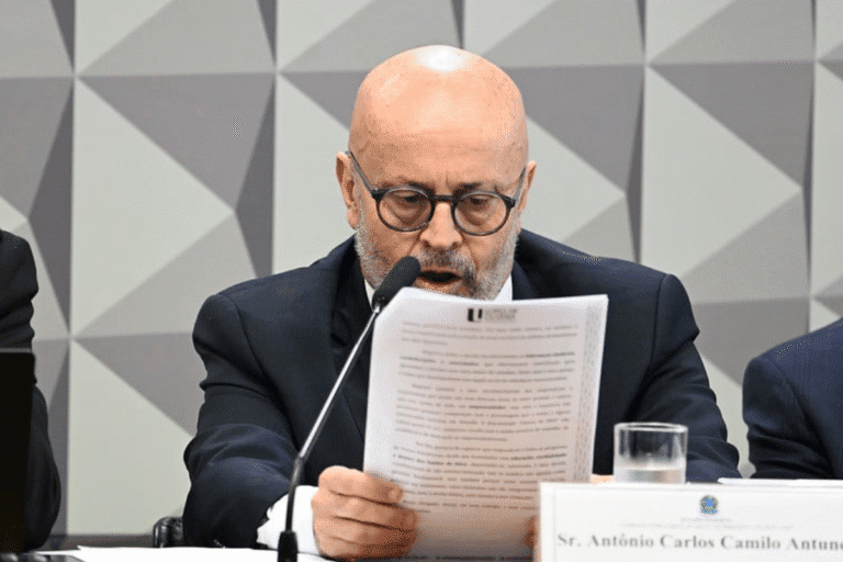 Homem lendo documento em uma reunião formal, usando óculos e vestindo terno, com fundo de painel moderno, destacando a importância do conteúdo atualizado.