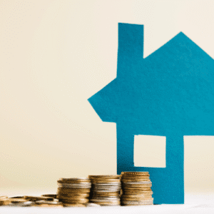 Imagem de uma casa em papel azul ao lado de pilhas de moedas, simbolizando investimento em imóveis e planejamento financeiro.
