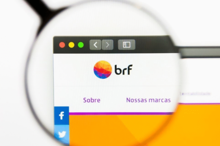 Captura de tela do site da brf visto através de uma lupa, destacando o logo colorido da empresa e o menu com as opções Sobre e Nossas marcas.
