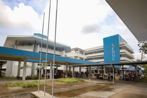 Instituição educacional Seduc com estrutura moderna e ampla, local de ensino e atividades acadêmicas, localizada em uma área com céu parcialmente nublado.