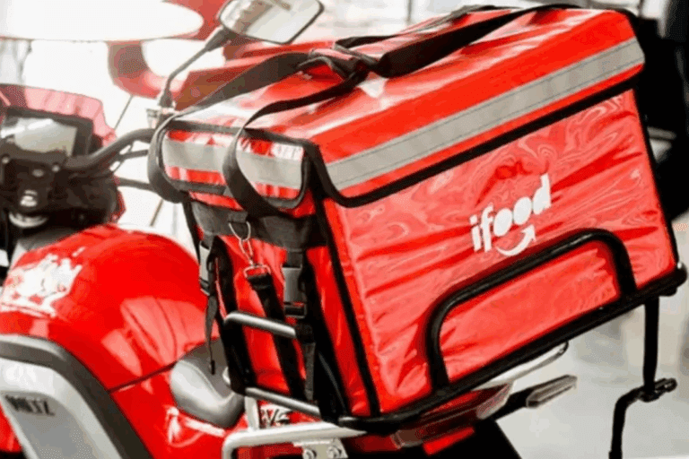 Moto de entregas com mochila térmica vermelha para delivery de alimentos, ideal para pizza, comida rápida, com alta visibilidade para motoristas.