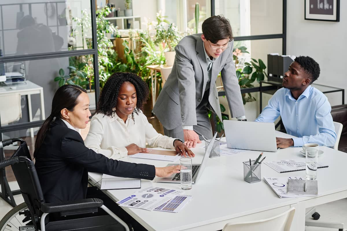 Equipe diversa em reunião de negócios discutindo estratégias de terceirização de serviços em um escritório moderno.