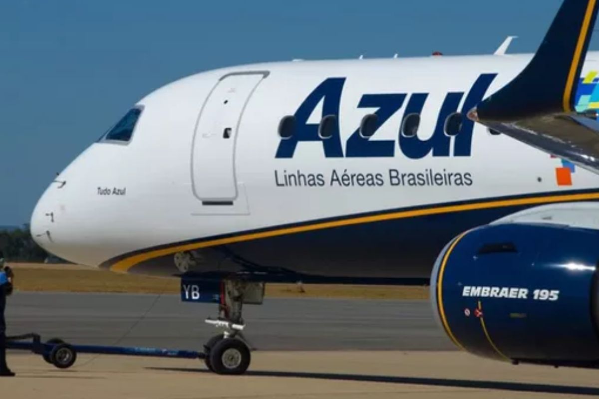 Avião da Azul Linhas Aéreas Brasileiras estacionado na pista de aeroporto, destacando a fuselagem com a marca Azul e o motor Embraer 195.