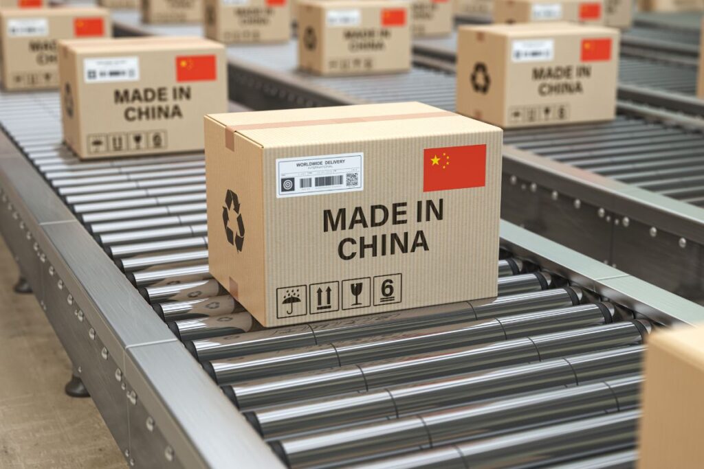 Caixa de papelão com a frase "Made in China" sendo transportada por uma esteira em um ambiente de embalagem.
