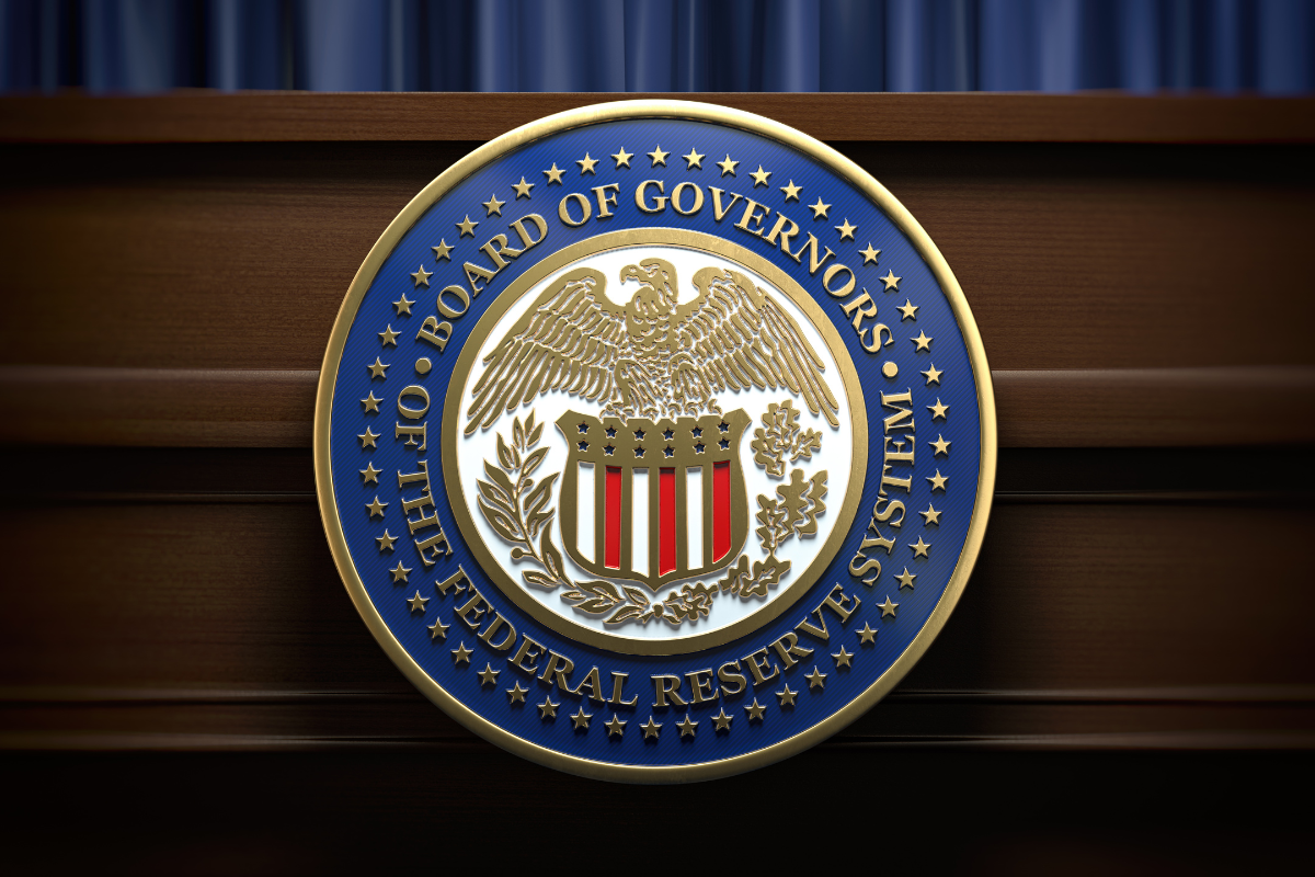 Emblema do Federal Reserve System dos Estados Unidos, mostrando o escudo central com uma águia dourada, cercado por uma fita azul com estrelas douradas, símbolo do sistema bancário americano.