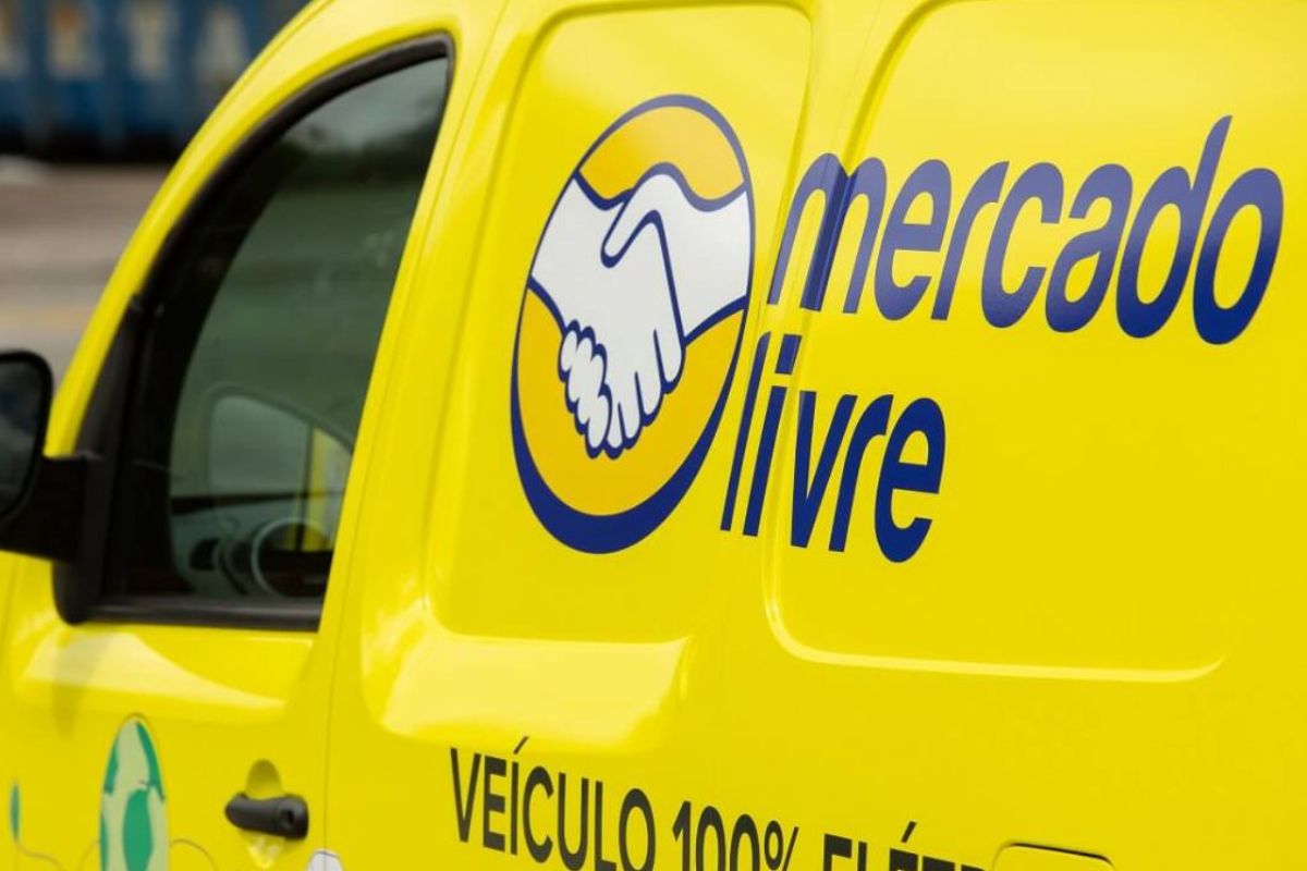 Veículo de entrega do mercado livre em cor amarela com logotipo azul de mãos dadas, indicando transporte de produtos da plataforma de comércio eletrônico