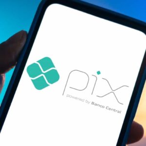 Aplicativo Pix no celular, método de pagamento digital do Banco Central do Brasil, com fundo de cores azul e laranja. Ótimo para transferência de dinheiro rápida.