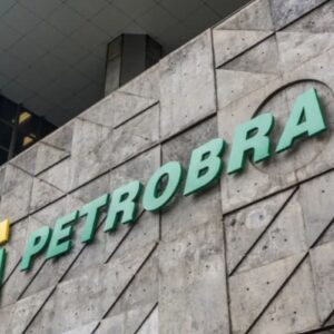 Fachada do edifício com o logo da Petrobras em destaque, apresentando uma estrutura moderna em concreto e vidro, localizado em uma área urbana.