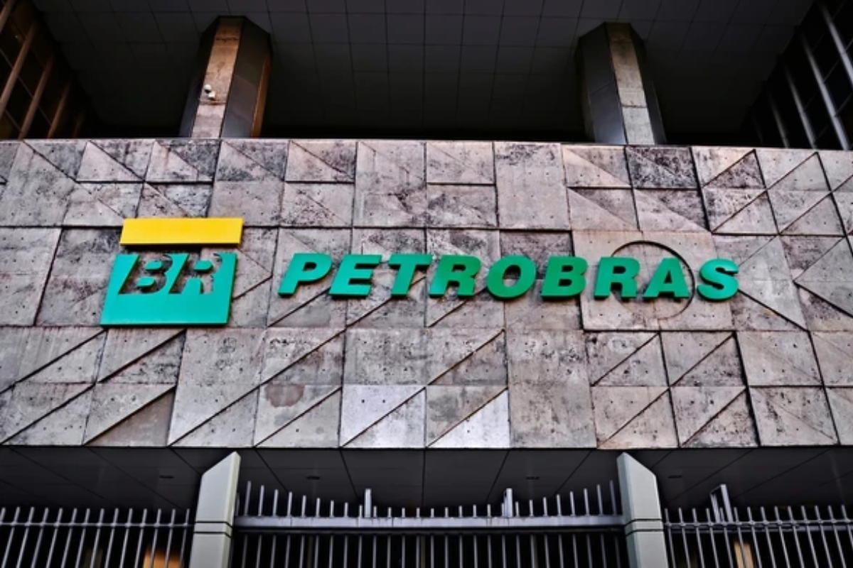 Fachada da Petrobras com destaque para o logo verde e amarelo em uma parede de pedra moderna.
