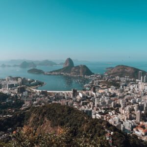 Visualização panorâmica da cidade do Rio de Janeiro com o Pão de Açúcar ao fundo e praias famosas, destacando a beleza natural e urbana do Brasil.