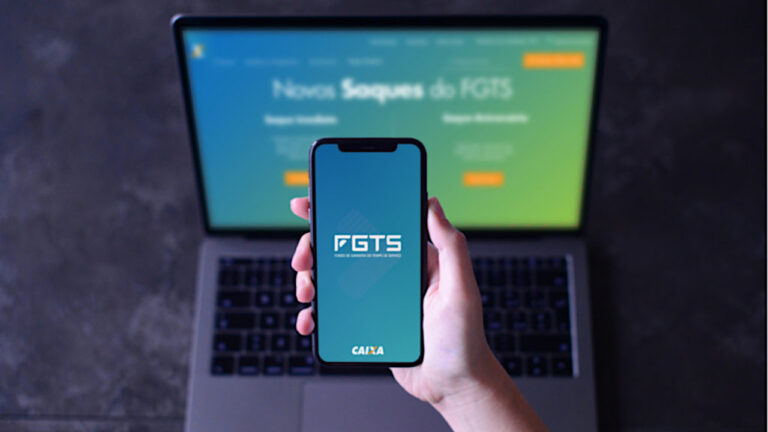 Computador e celular com o app do FGTS, ilustrando a notícia Ministro do Trabalho, Luiz Marinho, anuncia novas regras do saque-aniversário FGTS em coletiva do governo federal.