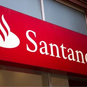 Loja do banco Santander com logotipo vermelho e branco, destaque para o nome Santander e símbolo de uma folha de bordo estilizada, em ambiente urbano.